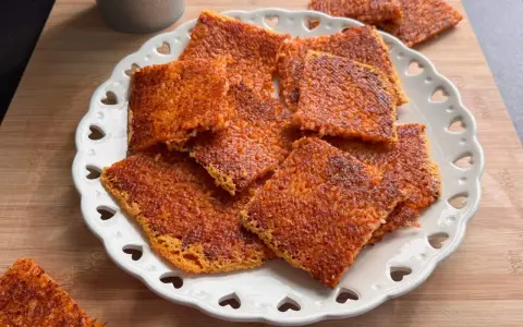 Schiacciata di riso croccante, dorata e invitante, servita su un piatto bianco decorato con cuoricini. Perfetta per uno snack goloso.
