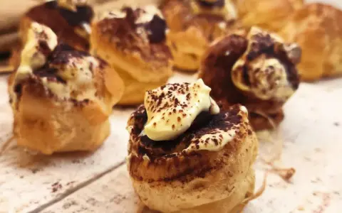 Bignè al tiramisù, deliziosi dolcetti con crema e cacao, pronti per essere gustati.