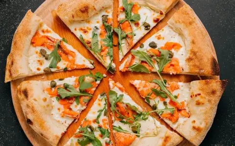 Fette di pizza con salmone affumicato, rucola e capperi, perfette come pizza sticks per un aperitivo.