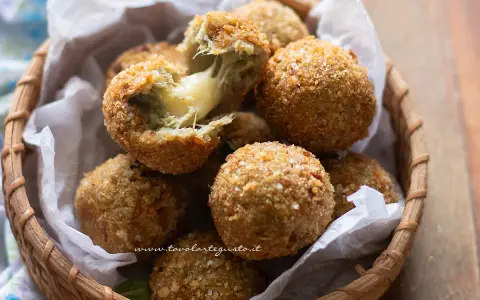 Deliziose polpette di carciofi alla siciliana, croccanti fuori e filanti dentro, servite in un cestino di vimini.