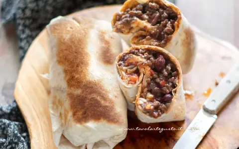 Burrito chili con carne ripieno di carne macinata, fagioli rossi e riso, pronto per essere gustato.