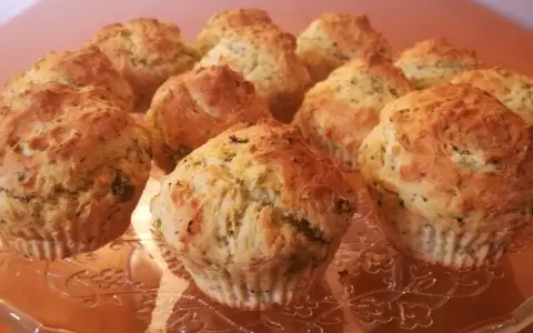 Muffin broccoli e patate dorati su un piatto di vetro decorato.