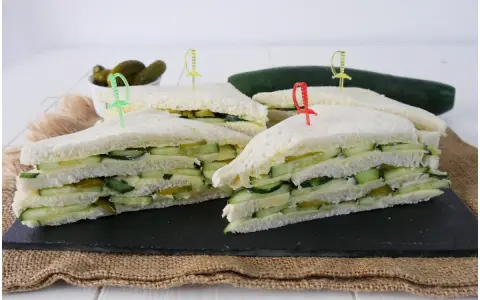 Tramezzini freschi con cetriolini sott'aceto, formaggio e cetriolo, pronti per un picnic.