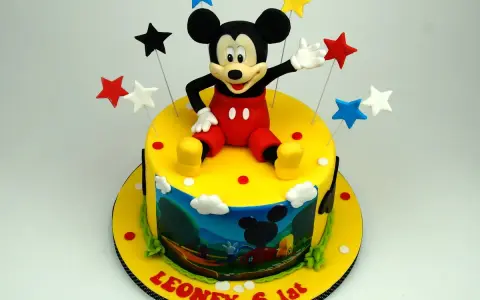 Un allegro tort Mickey Mouse con stelle colorate e una scena del cartone animato sul lato. Leone festeggia 6 anni!