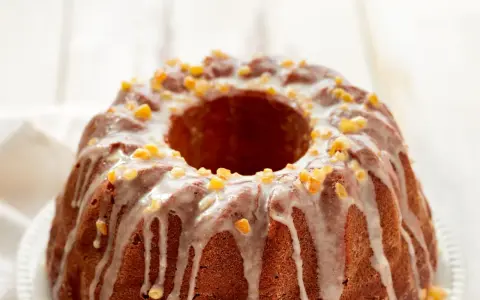 Dolce ciambellone glassato con scorzette d'arancia candita, perfetto per il tuo murzynek przepis.