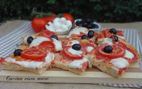 Fette di pizza saporita con pomodoro fresco, mozzarella filante e olive nere. Ingredienti semplici per un gusto autentico.