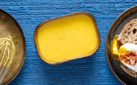 Salsa olandese, perfetta per la tua sfoglia olandese ricetta. Accanto, un uovo in camicia su pane tostato.