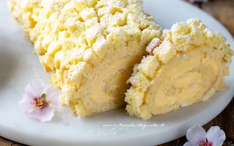 Tronchetto mimosa soffice e cremoso, decorato con briciole di pan di Spagna e fiori rosa.