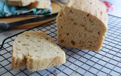 Fetta di pane soffice e dorata, appena sfornata, su una griglia. Il pane con cremor tartaro è pronto per essere gustato.