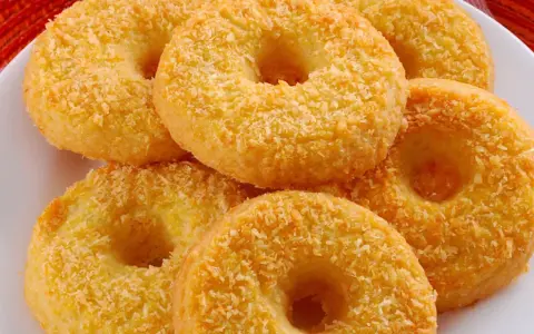 Oponki serowe, dorate con cocco grattugiato, invitano a un dolce assaggio.