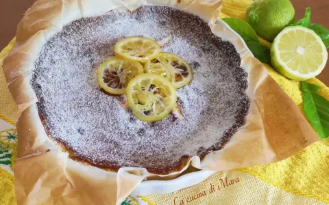 Torta al limone cosparsa di zucchero a velo, decorata con fette di limone caramellate. Freschezza e dolcezza in un morso.