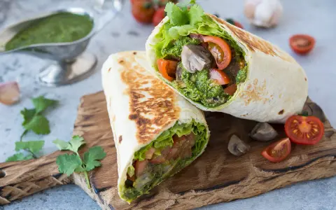 Piadina con pesto, pomodoro e lattuga, un pasto fresco e saporito.
