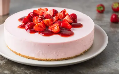 Cheesecake rosa con fragole fresche e salsa, un dolce delizioso, perfetto per ogni occasione.