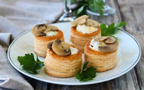 Quattro vol au vent funghi e formaggio, un antipasto sfizioso e gustoso, guarniti con prezzemolo fresco.