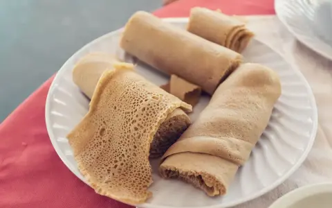 Piadina africana, un piatto di injera arrotolata, con la sua tipica trama alveolata, pronta per essere gustata.