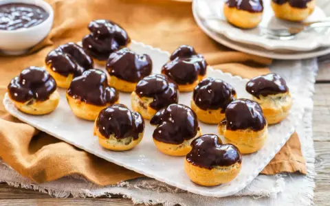 Bignè al cioccolato ricetta: deliziosi bignè ripieni e glassati al cioccolato fondente, pronti per essere gustati.