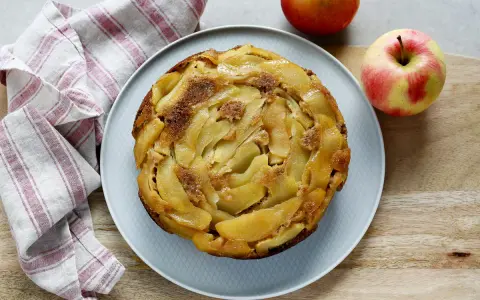 Deliziosa torta rovesciata di mele e noci, con mele caramellate disposte a spirale e una spolverata di zucchero di canna.