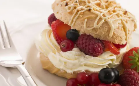 Deliziosi pasticcini con crema chantilly e frutti di bosco freschi, un'esplosione di dolcezza e freschezza.