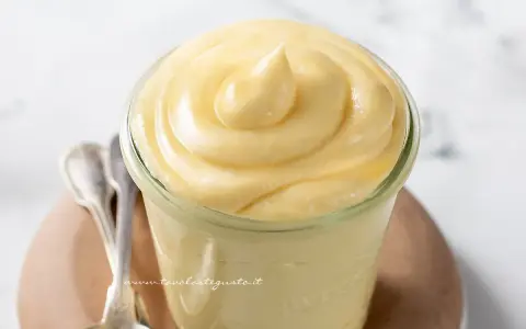 Crema chiboust ricetta originale in un vasetto, con cucchiaini d'argento accanto.