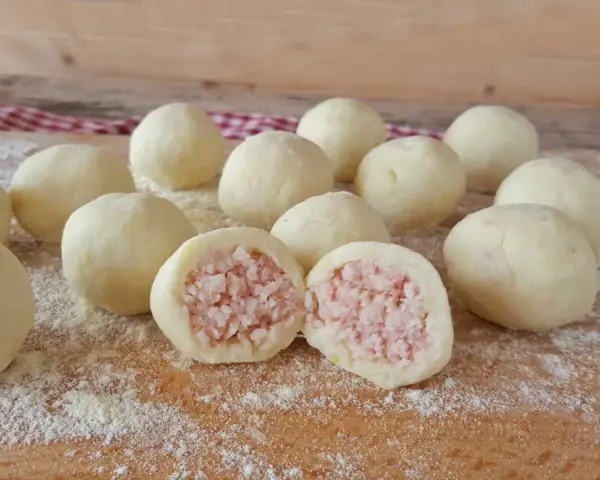 Sfere di gnocco di patate ripieno, pronte per essere cucinate. Una delizia fatta in casa.