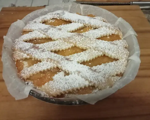 Una deliziosa crostata pasqualina salata, con un intreccio di pasta frolla cosparso di zucchero a velo, pronta per essere gustata.