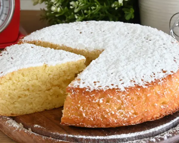 Delizioso ciasto jogurtowe, soffice e cosparso di zucchero a velo, pronto per essere gustato.
