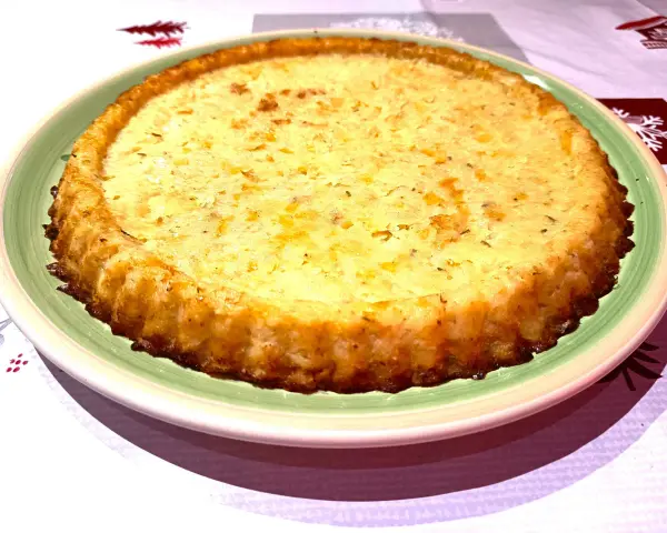Tortino di patate con salmone e mozzarella, dorato e invitante, pronto per essere gustato.