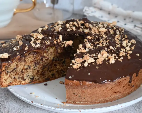 Torta soffice con amaretti e cioccolato fondente, glassata al cioccolato e cosparsa di briciole croccanti.