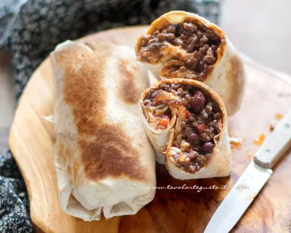 Burrito chili con carne ripieno di carne macinata, fagioli rossi e riso, pronto per essere gustato.
