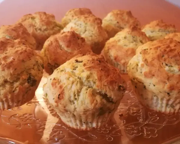 Muffin broccoli e patate dorati su un piatto di vetro decorato.