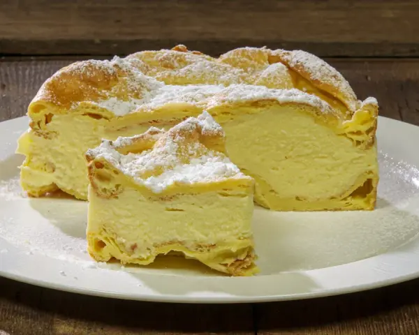 Fetta di Karpatka, dolce polacco con crema pasticcera e pasta choux, spolverata di zucchero a velo. Un delizioso karpatka przepis.