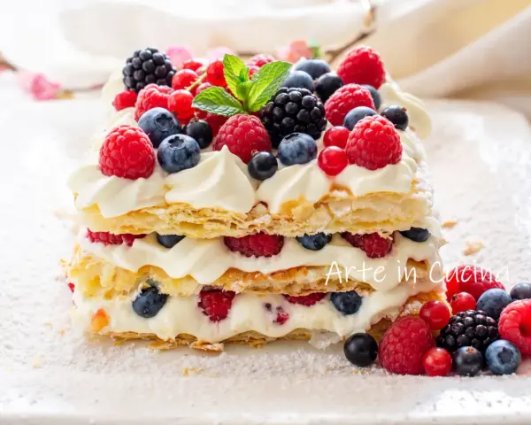 Delizioso millefoglie con frutta fresca, panna montata e un tocco di zucchero a velo. Un tripudio di lamponi, mirtilli e more.