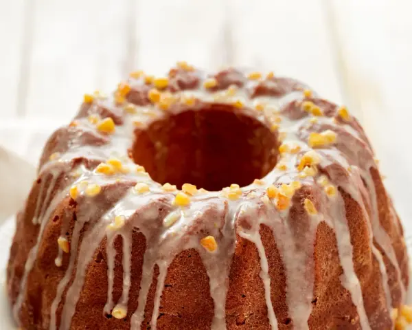 Dolce ciambellone glassato con scorzette d'arancia candita, perfetto per il tuo murzynek przepis.