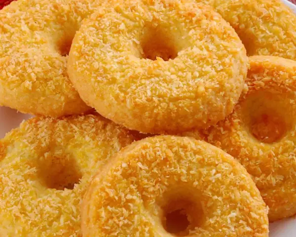 Oponki serowe, dorate con cocco grattugiato, invitano a un dolce assaggio.