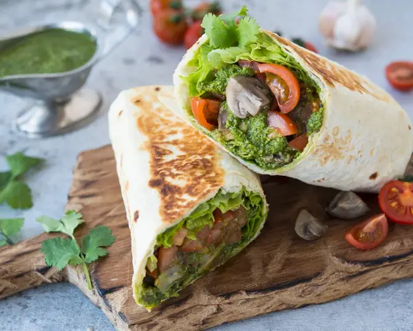 Piadina con pesto, pomodoro e lattuga, un pasto fresco e saporito.