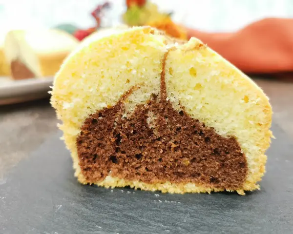 Fetta di ciambella bicolore, chiara e al cacao, soffice e gustosa, perfetta come ciambella per celiaci.