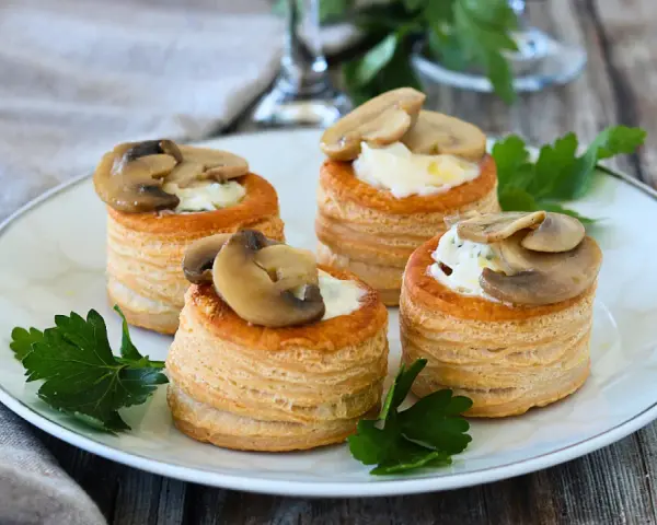 Quattro vol au vent funghi e formaggio, un antipasto sfizioso e gustoso, guarniti con prezzemolo fresco.
