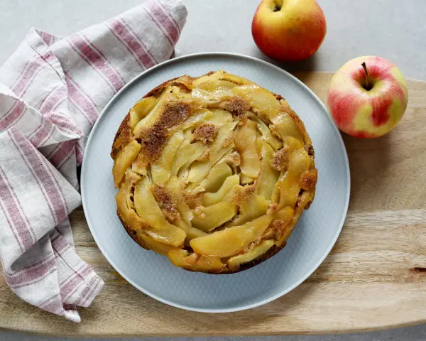 Deliziosa torta rovesciata di mele e noci, con mele caramellate disposte a spirale e una spolverata di zucchero di canna.