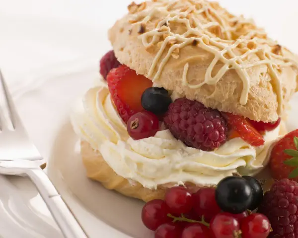 Deliziosi pasticcini con crema chantilly e frutti di bosco freschi, un'esplosione di dolcezza e freschezza.