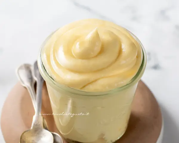 Crema chiboust ricetta originale in un vasetto, con cucchiaini d'argento accanto.