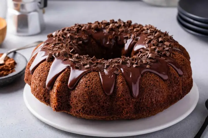 Delizioso ciambellone al cioccolato, perfetto per il tuo lukier przepis. Glassa lucida e scaglie di cioccolato per un tocco goloso.