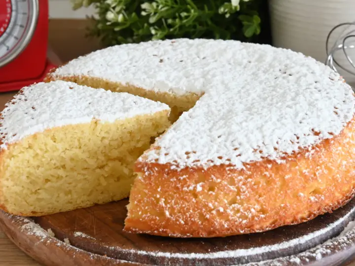 Delizioso ciasto jogurtowe, soffice e cosparso di zucchero a velo, pronto per essere gustato.