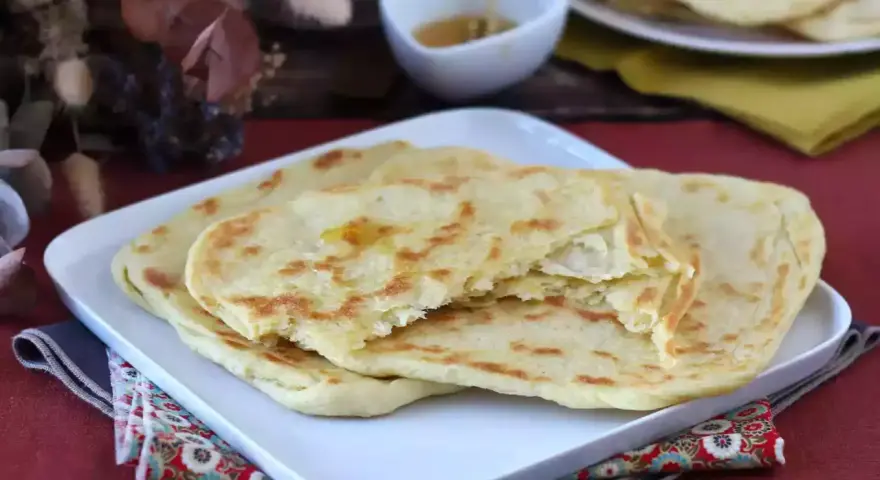 Msemmen marocchino, sfogliato e dorato, pronto per essere gustato con miele. Una deliziosa ricetta da provare.