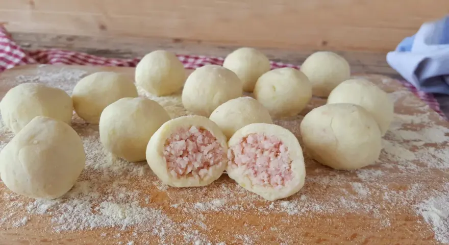 Sfere di gnocco di patate ripieno, pronte per essere cucinate. Una delizia fatta in casa.
