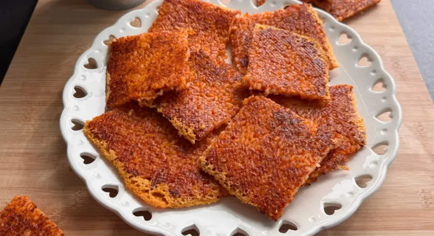 Schiacciata di riso croccante, dorata e invitante, servita su un piatto bianco decorato con cuoricini. Perfetta per uno snack goloso.