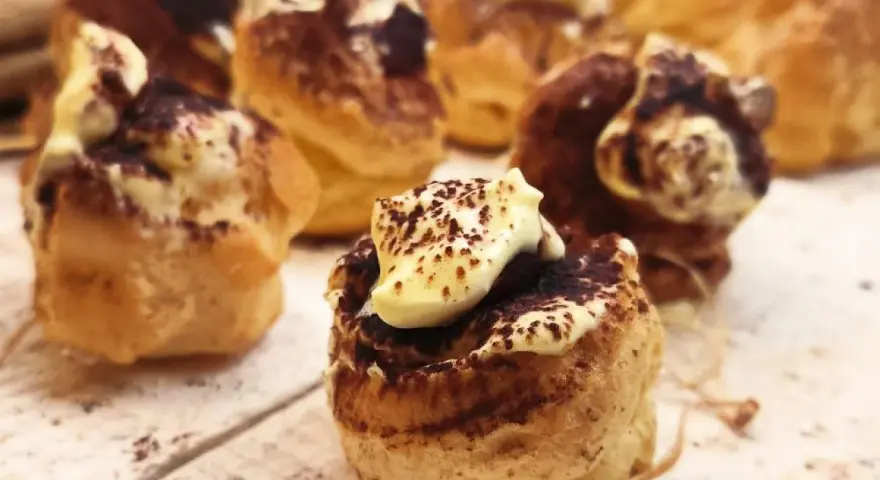 Bignè al tiramisù, deliziosi dolcetti con crema e cacao, pronti per essere gustati.