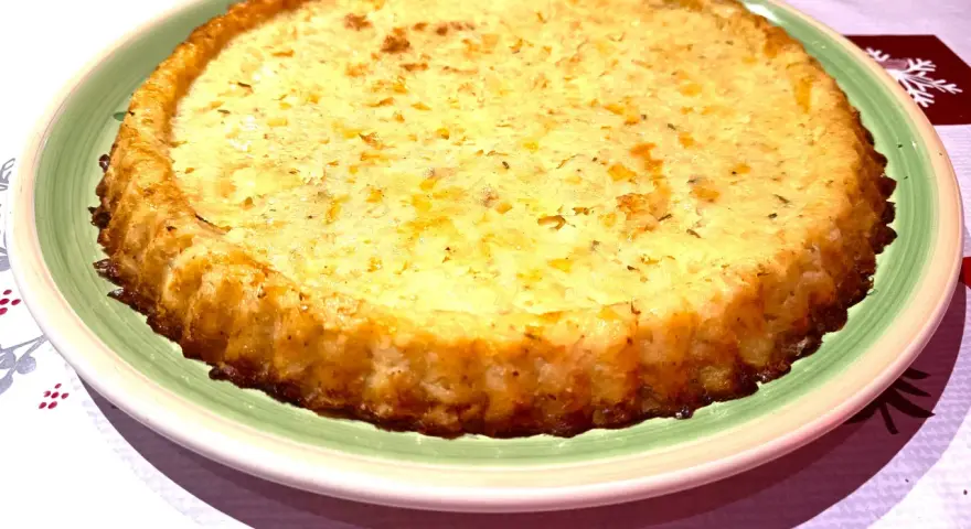 Tortino di patate con salmone e mozzarella, dorato e invitante, pronto per essere gustato.