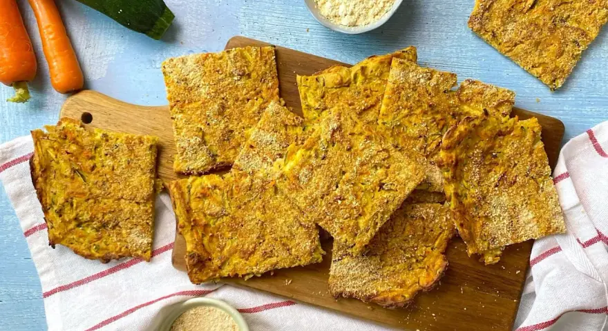 Schiacciata verdure dorata e croccante, con zucchine e carote, pronta per essere gustata.