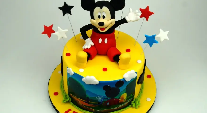 Un allegro tort Mickey Mouse con stelle colorate e una scena del cartone animato sul lato. Leone festeggia 6 anni!