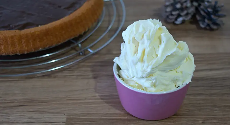 Crema al mascarpone senza zucchero, soffice e invitante, pronta per guarnire una torta al cioccolato.